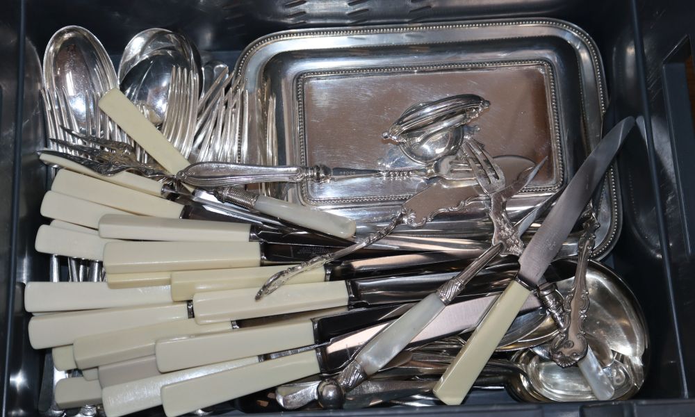 Assorted plated flatware, plated entree dish and soup ladle.